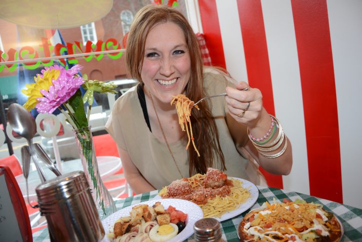 Young woman in restaurant eating pasta