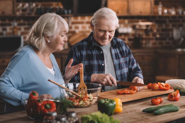 Elderly couple preparing fresh vegetables for a meal