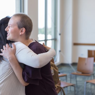 Cancer patient hugging a supportive woman