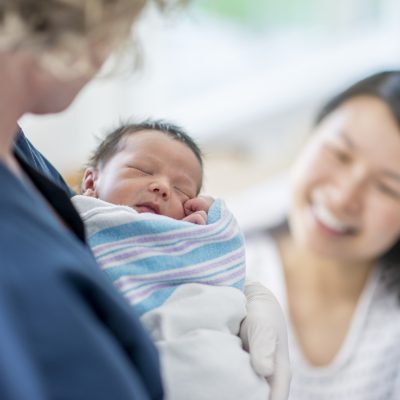 Newborn baby in the nurse's arms