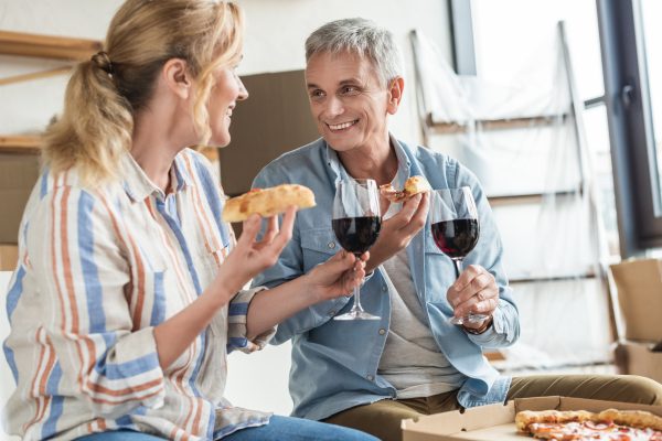 Couple eating pizza and drinking wine