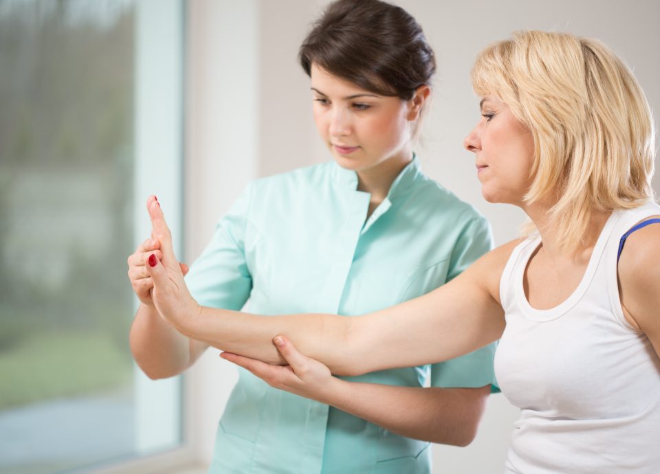 Therapist examining female patient's wrist