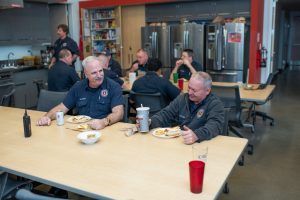 Men in uniform enjoying meal in large kitchen