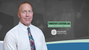 Timothy Custer, MD stands against grey background