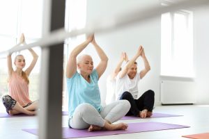 Senior woman doing yoga in exercise class