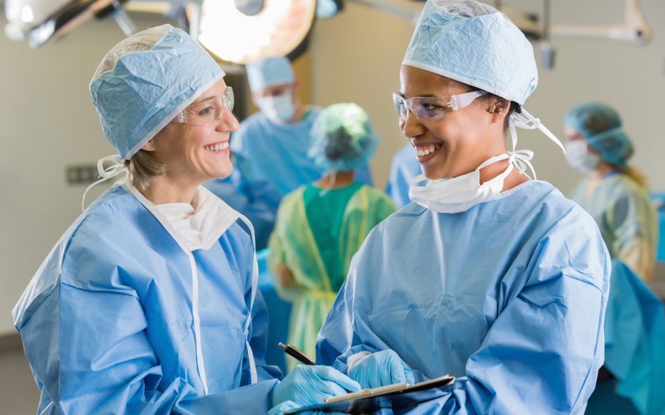 Female surgeons consulting about patient in operating room
