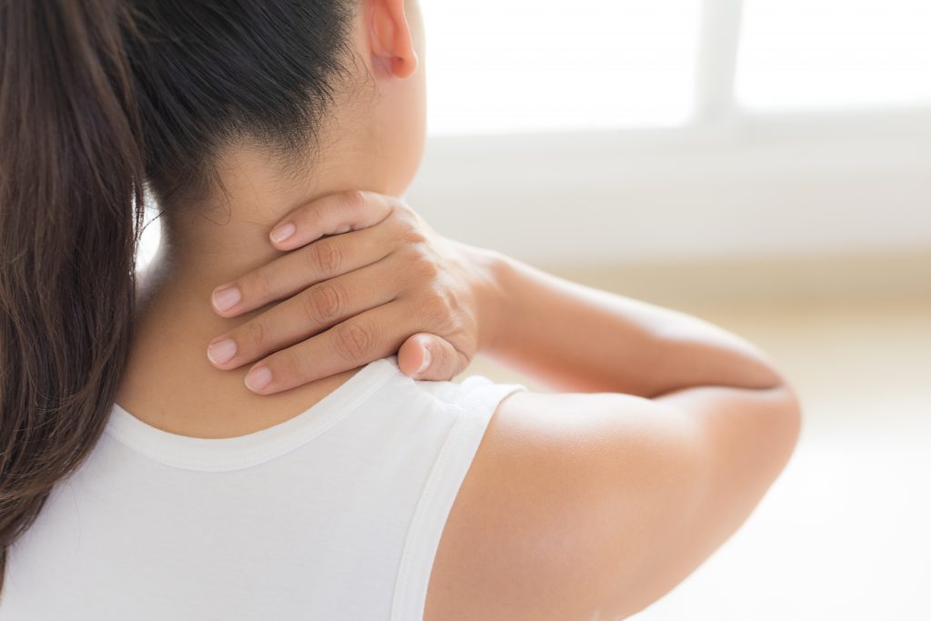 woman holding neck in pain