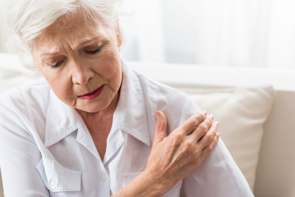 woman holding shoulder in pain