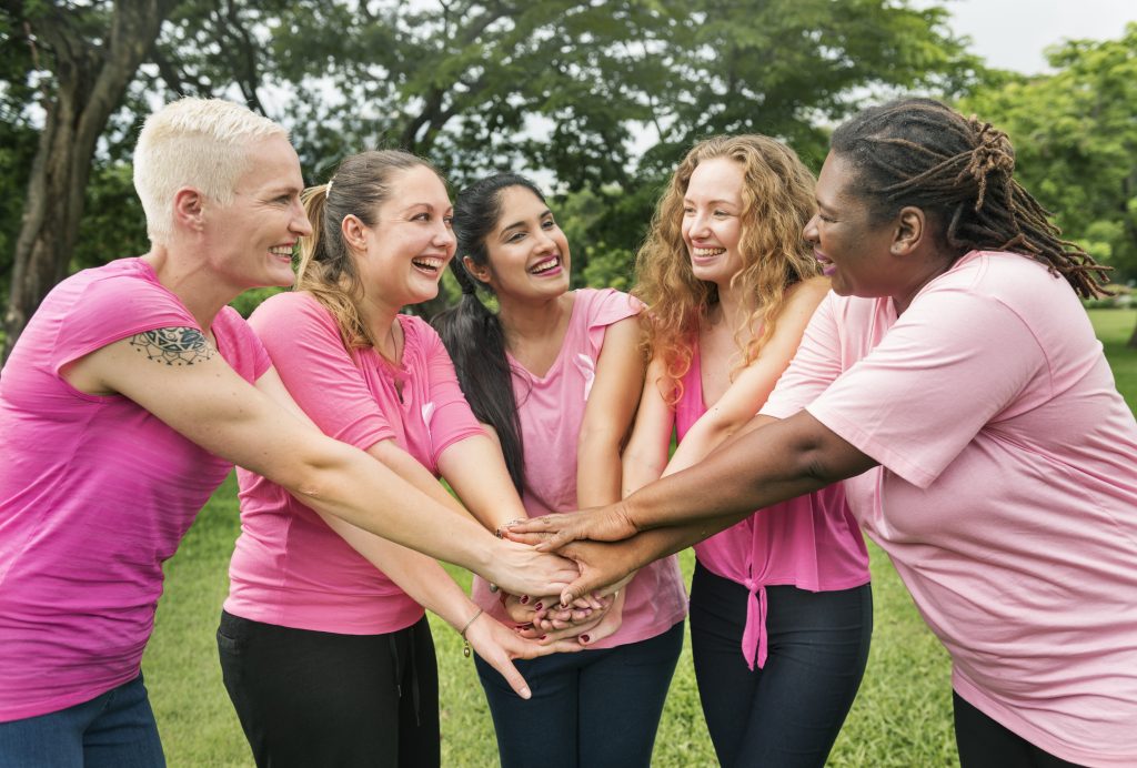 Women in pink shirts with hands together
