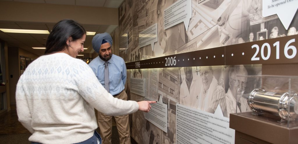 Dr. Singh and daughter, Dr. Singh, explore the Centennial Wall at FMC