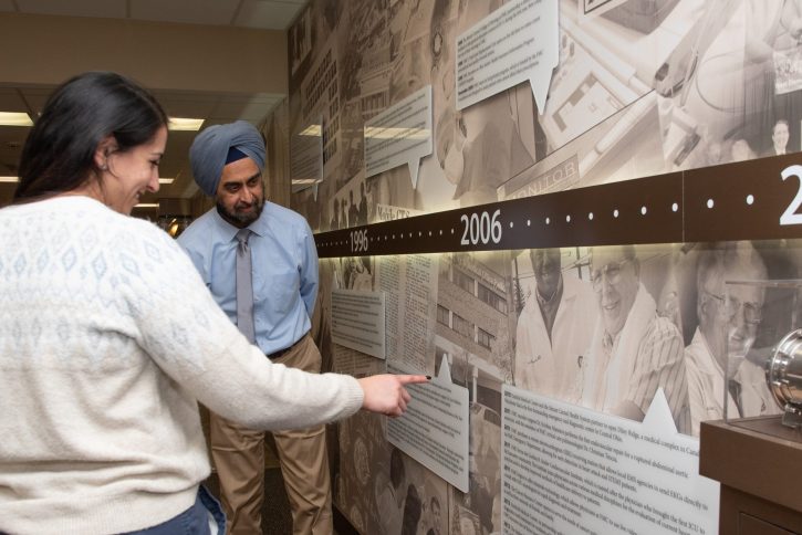 Dr. Singh and daughter, Dr. Singh, explore the Centennial Wall at FMC